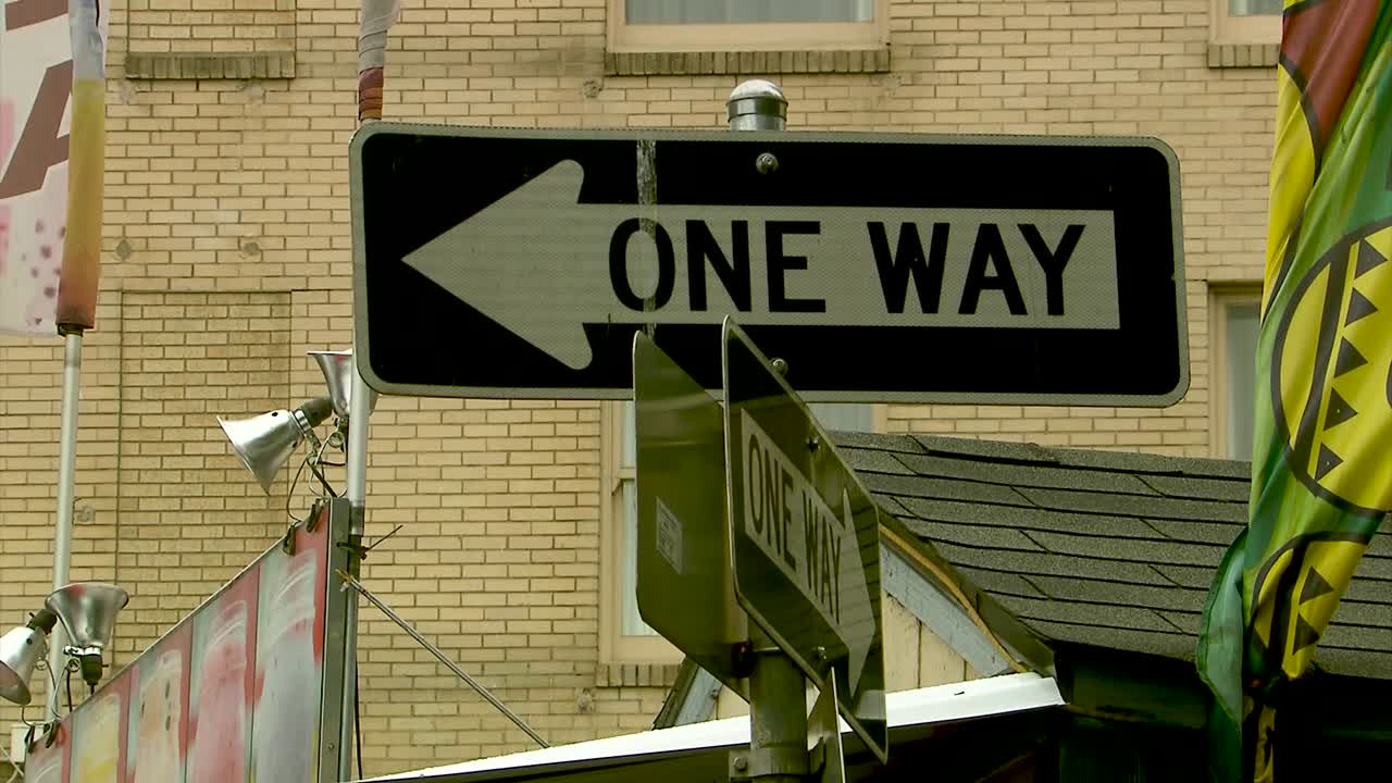 A close up of a One Way sign in the city