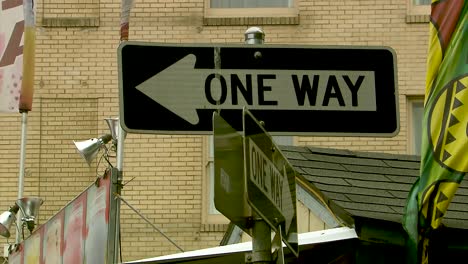 a close up of a one way sign in the city