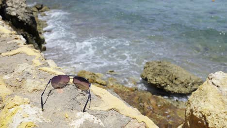 sunglasses lying on stone fence