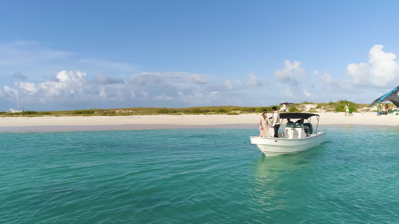 novia recién casada y lista para saltar agua de mar desde lancha motora, playa caribeña con toma aérea