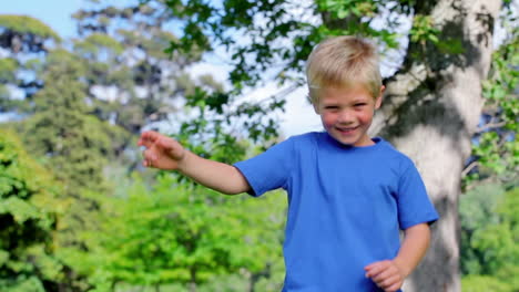 boy jumping in a park with his arms raised