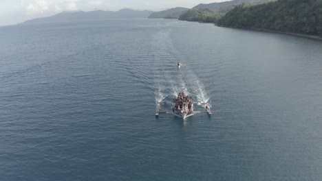 outrigger fishing boat fully loaded with local fishermen sailing in a tropical philippine island