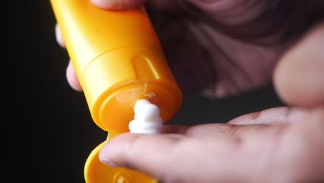 close-up of someone applying sunscreen to their hand