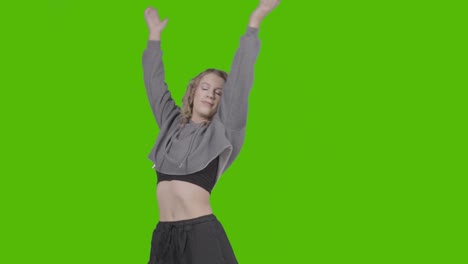 studio shot of young woman having fun dancing against green screen 11