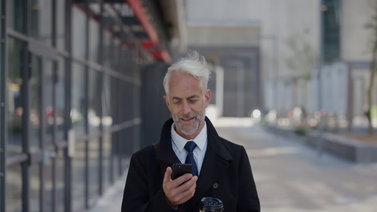 portrait successful middle aged businessman using smartphone in city enjoying texting browsing messages on mobile phone happy senior entrepreneur communicating online slow motion