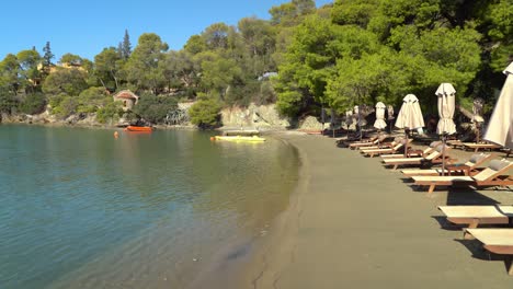 sunbeds on love's bay beach in poros island greece