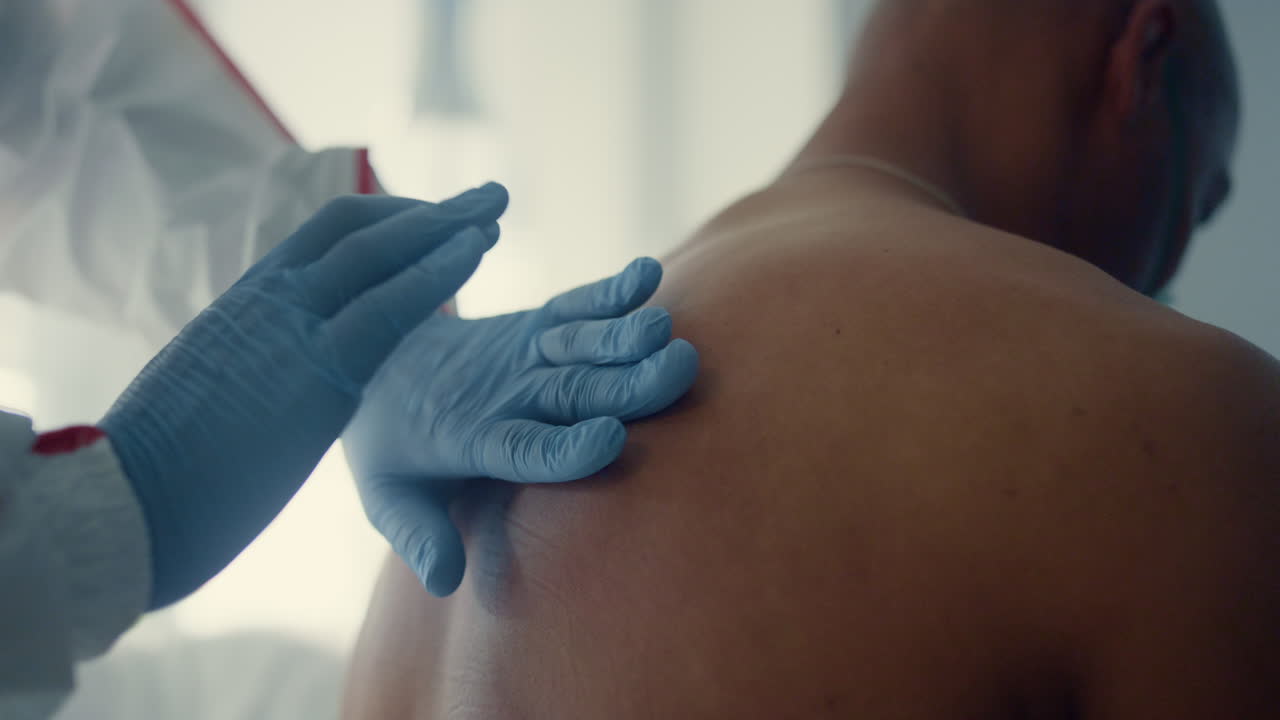 médico de primer plano examinando la espalda manualmente. médico desconocido chequeo para neumonía.