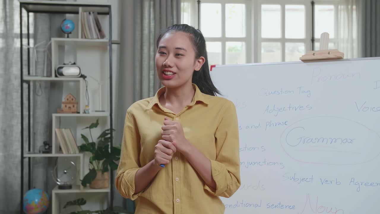 Asian Female Teacher With Marker Pen Teaching English At Home