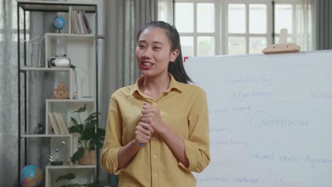 asian female teacher with marker pen teaching english at home