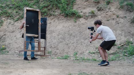 Cameraman-film-shooting-instructor-place-wooden-target-object-near-sand-hill