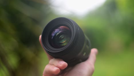 hand holding and slowly rotating a camera lens