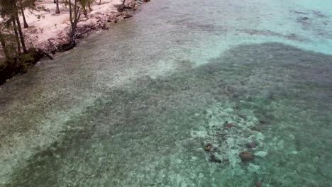 Playa-De-Arena-Blanca-En-Una-Isla-Tropical-Rodeada-De-Arrecifes-De-Coral-Y-Aguas-Cristalinas,-Vista-Aérea