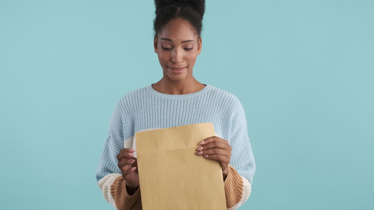 una mujer alegre abriendo un sobre.