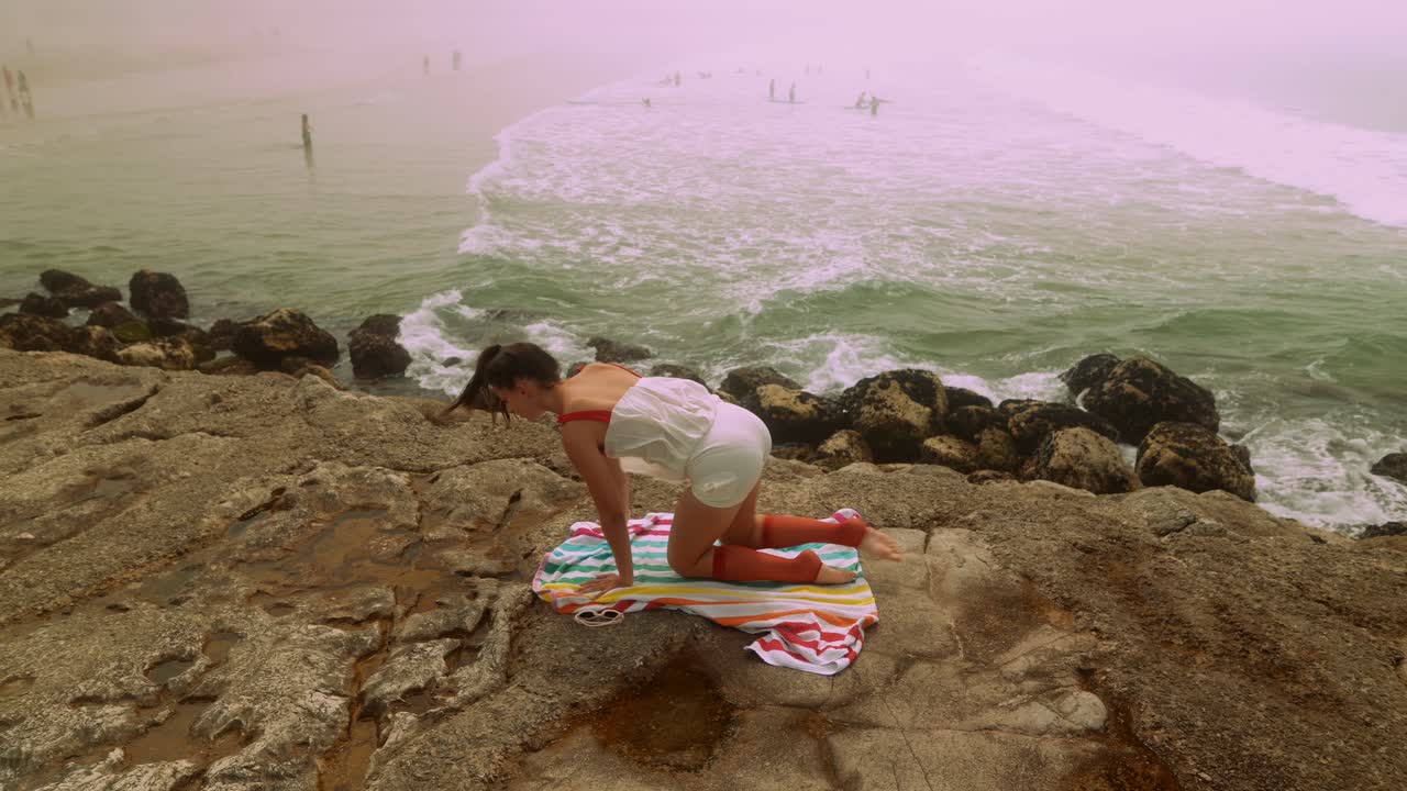 Jovem Mulher Praticando Yoga em Costa Rochosa com Vista para o Oceano Nebuloso