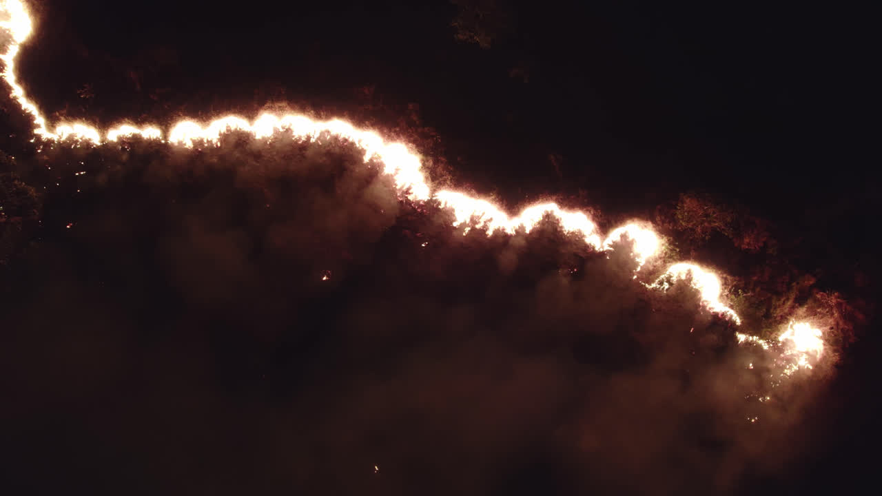Beautiful spreading fire flames and smoke at night dividing the screen ...
