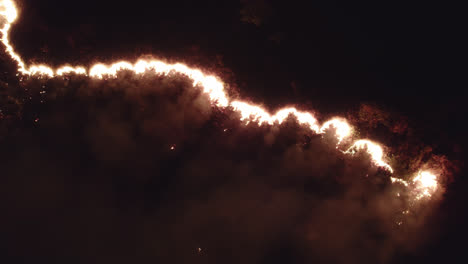 beautiful spreading fire flames and smoke at night dividing the screen in half
