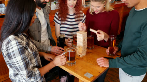 Gruppe-Von-Unholden,-Die-Jenga-Spielen,-Während-Sie-Bier-Trinken-4k