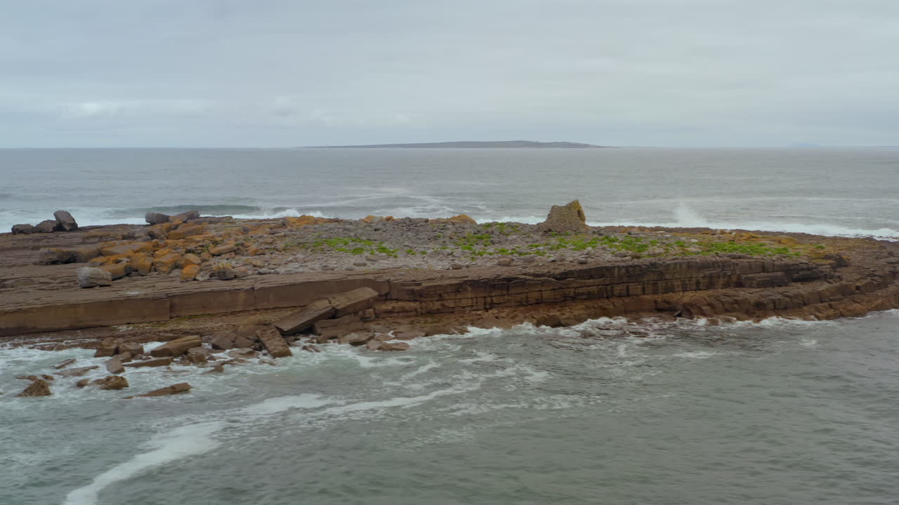 Aerial orbit of Crab Island revealing Inisheer in the background on an overcast day. Ireland