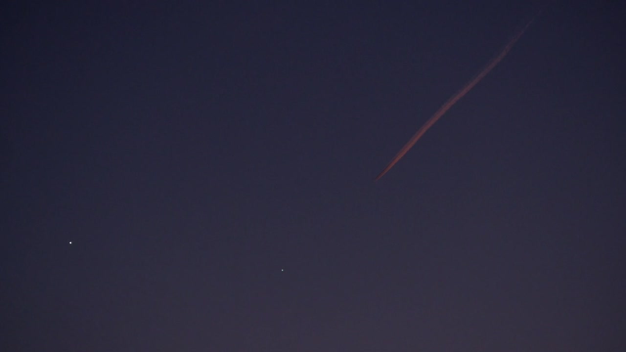 airplane in the sky leave behind chemtrails during sunset lights