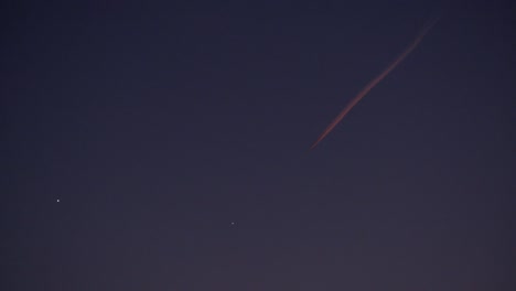 airplane in the sky leave behind chemtrails during sunset lights