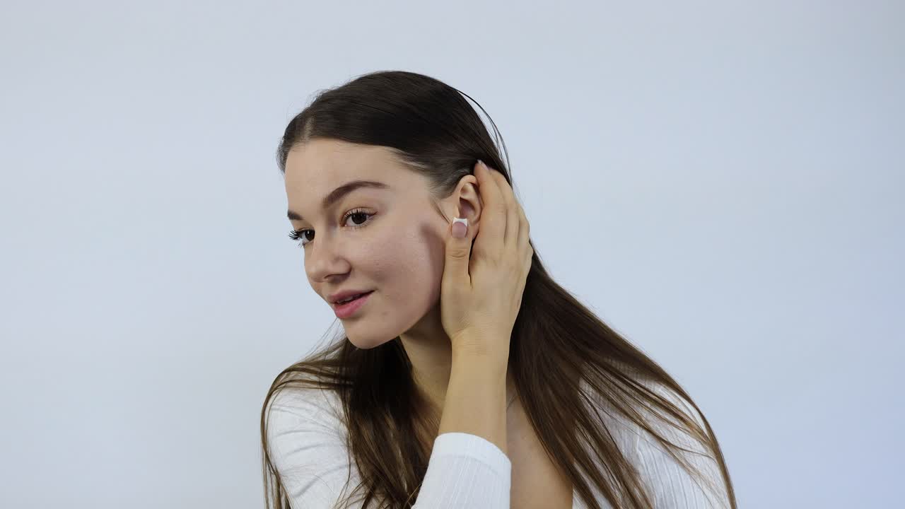 미소 짓는 젊은 여성이 카메라를 바라보며 행복하고 기분이 좋습니다.