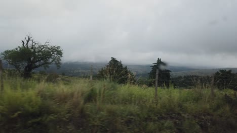 POV-Window-Seat-View,-Car-Drives-Argentine-Córdoba-Sierras,-Rainy-Cloudy-Skyline