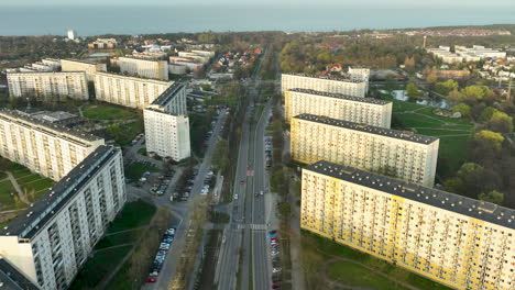 Aerial-shot-captures-a-broad-avenue-slicing-through-a-uniform-residential-district,-lined-by-rows-of-large-apartment-blocks---Gdańsk,-Żabianka