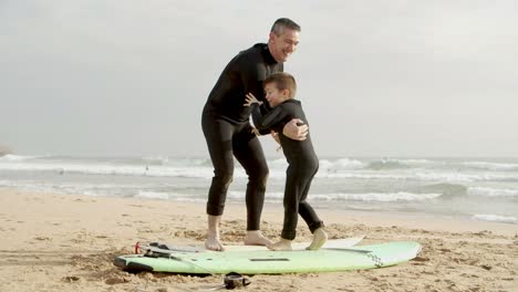 padre e hijo con tablas de surf en la playa