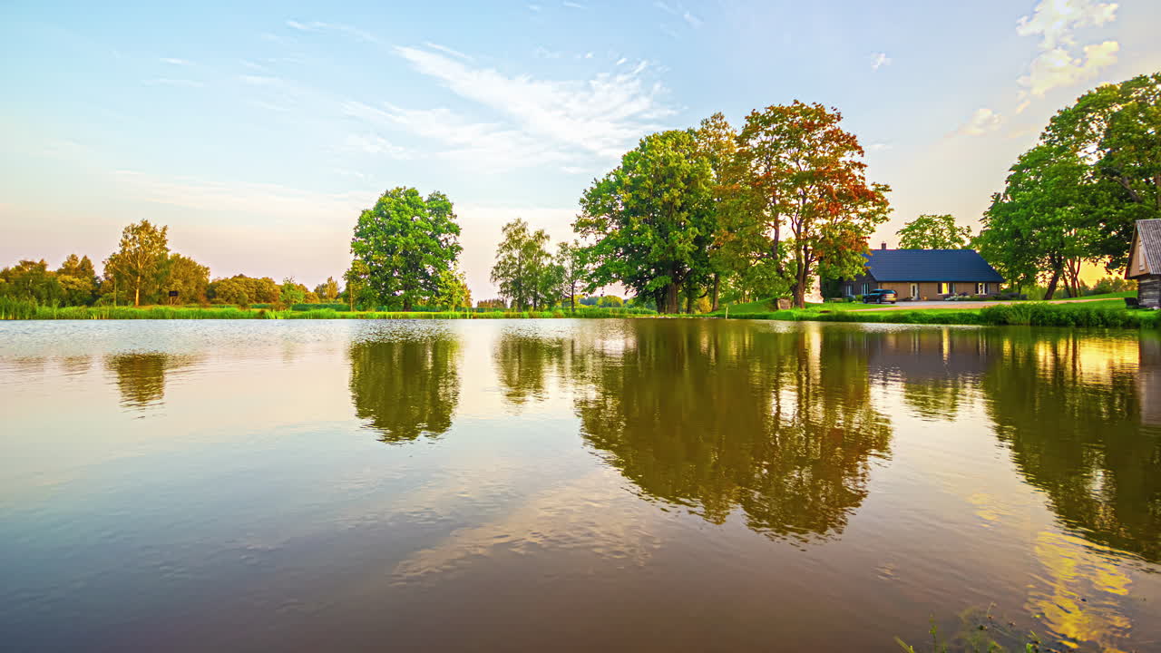 흐린 날 의 배경 에 마을 의 집 들 과 함께 호수 물 위 를 지나가는  ⁇  구름 의 반사 의 타임  ⁇ 스  ⁇