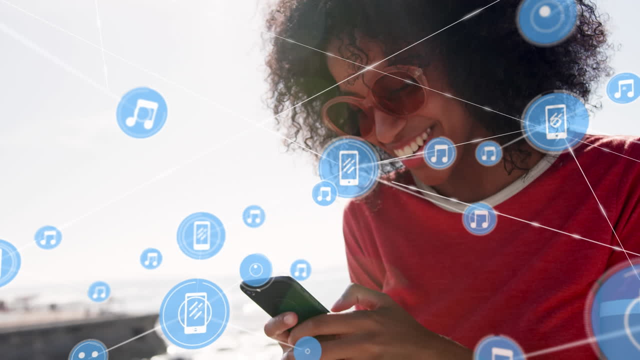 red de iconos digitales contra una mujer afroamericana que usa un teléfono inteligente en la playa