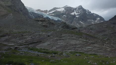 Stunning-mountain-landscape-in-Valmalenco,-tilt-up-reveals-snowy-peaks