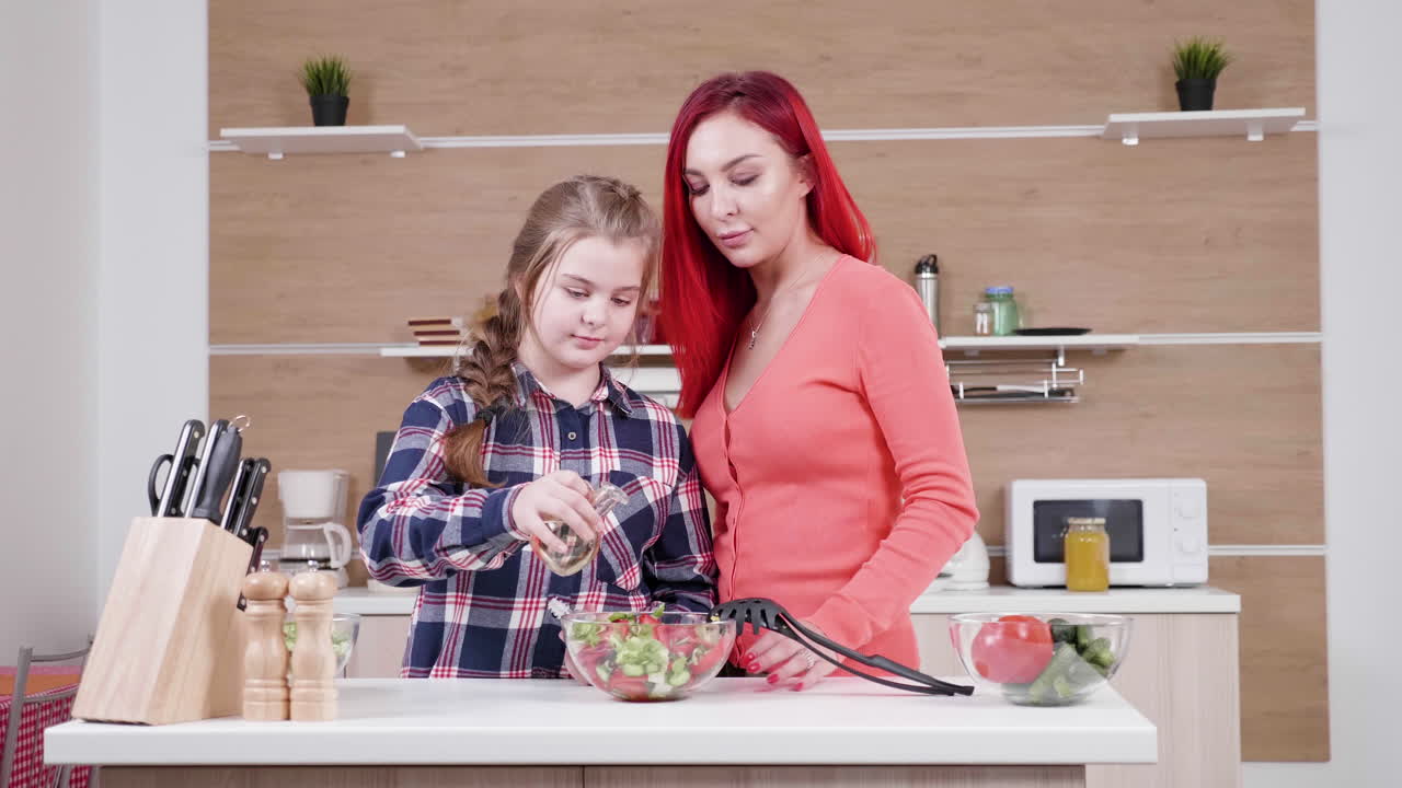 Mother and Daughter Cooking Salad in Kitchen