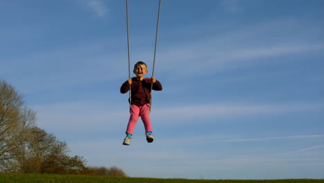 happy child swinging against a blue sky