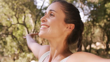 Woman-standing-in-park-with-her-arms-stretched