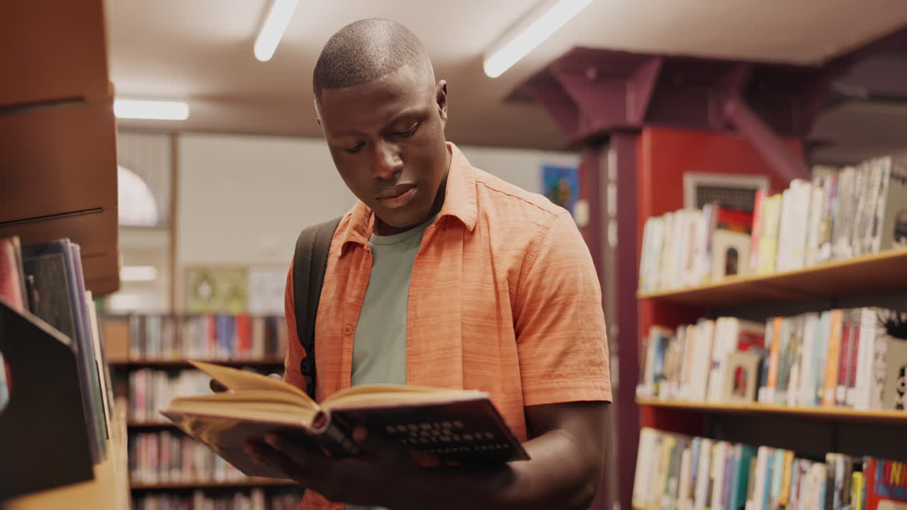 hombre leyendo un libro en una biblioteca