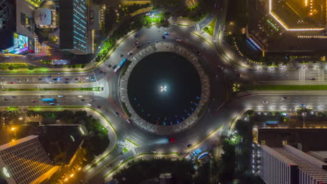 Ojo-De-Pájaro-Aéreo-Vista-De-Arriba-Hacia-Abajo-Hiperlapso-De-Tráfico-De-Automóviles-Ocupado-En-La-Rotonda-Alrededor-Del-Monumento-Selamat-Datang-En-Yakarta-Por-La-Noche,-Lapso-De-Tiempo-De-Movimiento-Hiperlapso