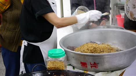 saborizante en polvo espolvoreado sobre arroz morado y relleno vegetal colocado en un tazón grande