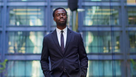 Portrait-Of-Confident-Young-Businessman-Adjusting-Suit-Standing-Outside-Offices-In-The-Financial-District-Of-The-City-Of-London-UK-1