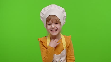 child girl dressed cook chef baker in apron and hat laughing out loud after hearing funny joke