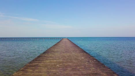 a flight over a wooden pier in the sea.