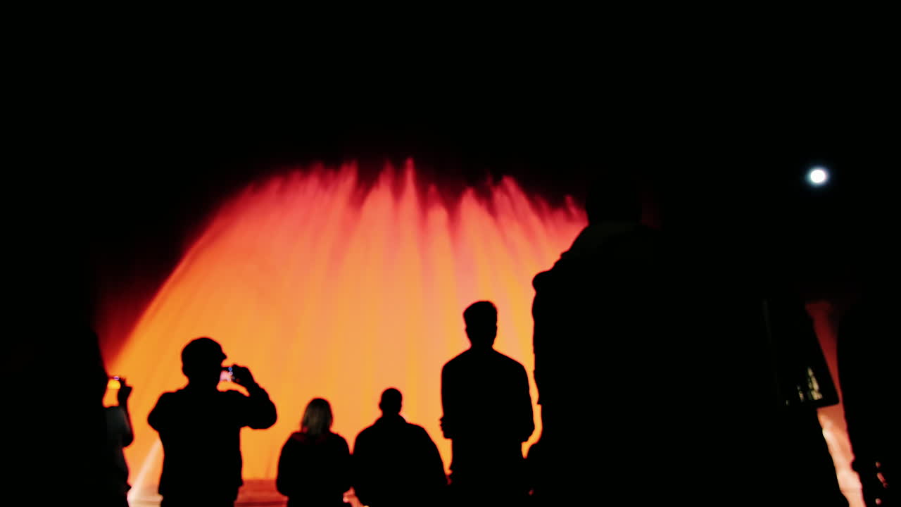 바르셀로나에서 조명으로 높은 분수를 감상하는 사람들의 실루엣