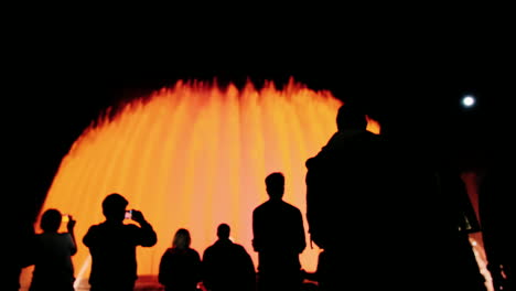 Silhouetten-Von-Menschen,-Die-Den-Hohen-Brunnen-Mit-Lichtern-In-Barcelona-Bewundern