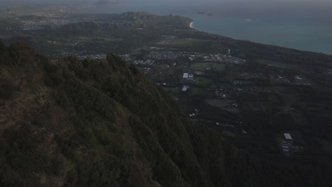 slow aerial pullback tilt over hawaii kai honolulu in the early morning over the mountains revealing the pacific ocean