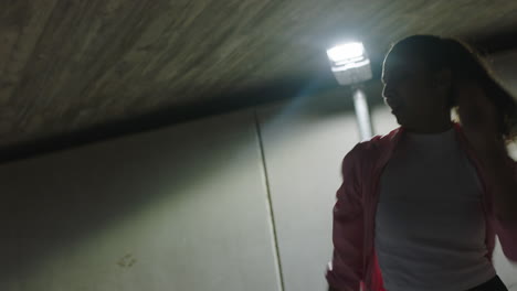 dancing-woman-young-street-dancer-practicing-modern-freestyle-dance-moves-under-street-light-in-city-at-night-close-up