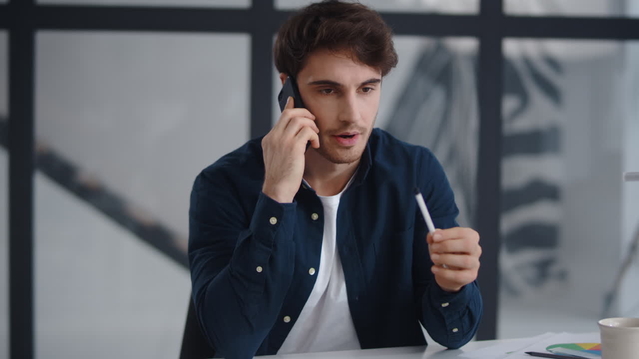 근접 초점을 맞춘 사업가 사무실에서 모바일로 이야기하고 있습니다. 프로젝트를 설명하는 남자
