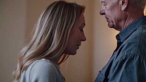 elderly father and his adult daughter are sharing a tender moment, their faces close together in a gesture of affection and love, highlighting the strong bond between generations