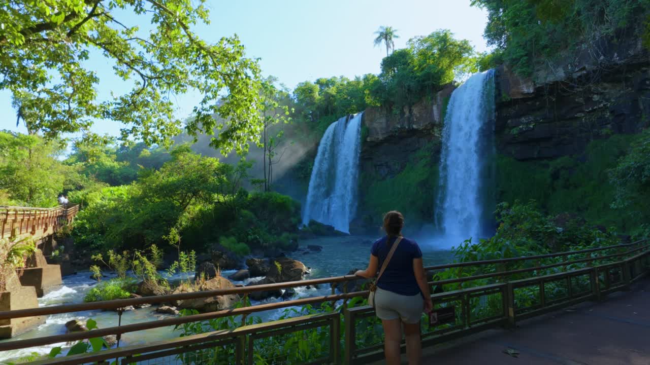 Turistas em trilhas e passarelas dentro do Parque Nacional do Iguaçu, na fronteira da Argentina e do Brasil. Imagem estática.