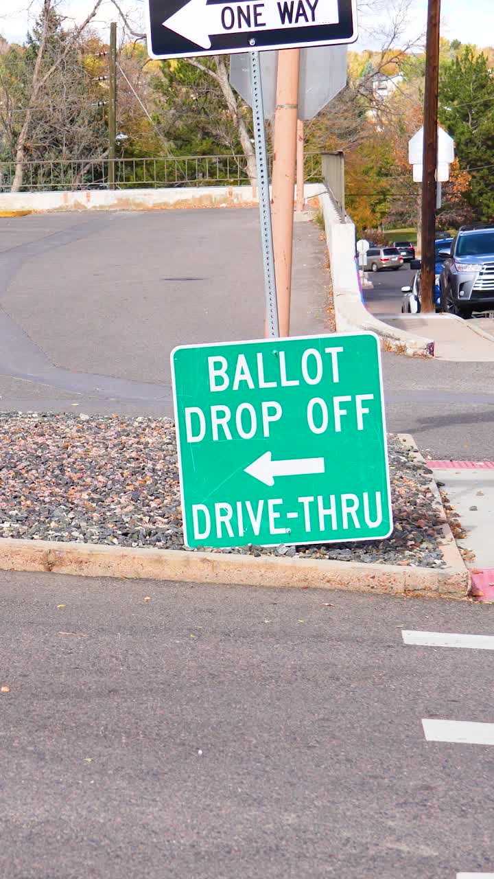 Vertical Video of a ballot drop-off sign with a bold arrow points toward a secure voting site, with a road in the background, highlighting civic responsibility, inclusivity, and election integrity
