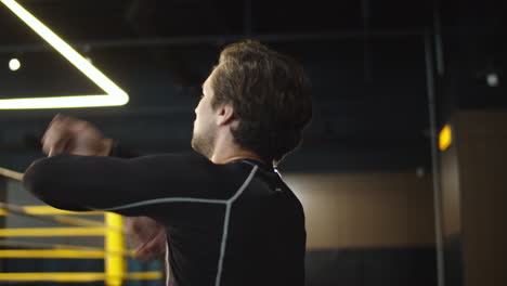 young male athlete warming up at gym