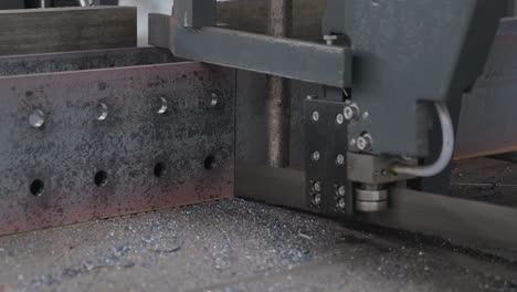 automated machine cutting metal beam slow motion